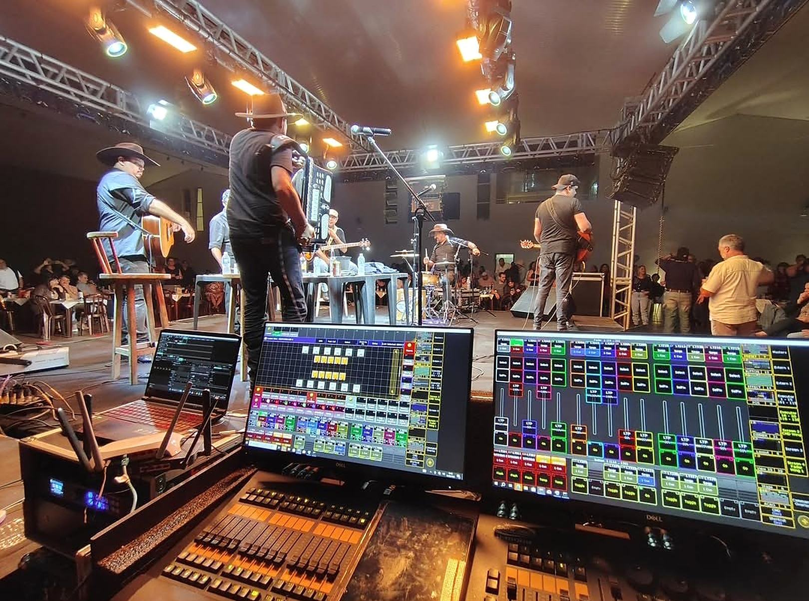 Mesas de som e luz operando show ao vivo